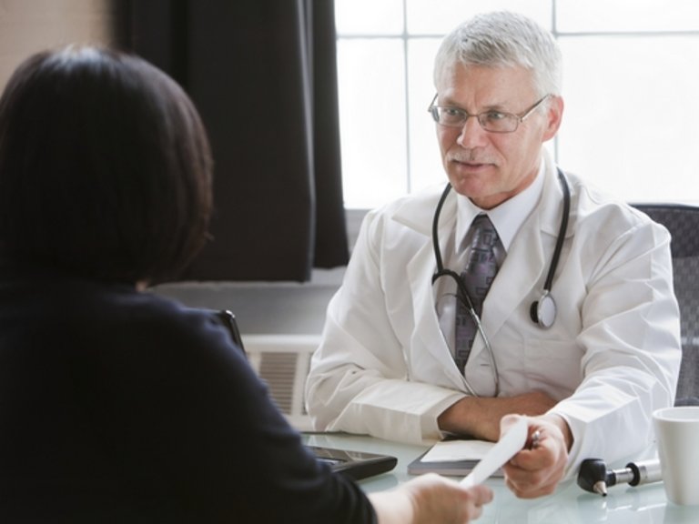 [Translate to Bosnia:] Male doctor talking to a patient