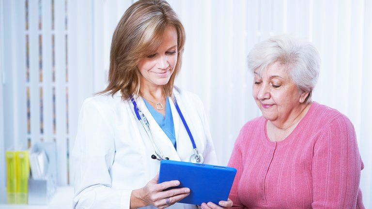 Ljekar i pacijent gledaju u tablet
